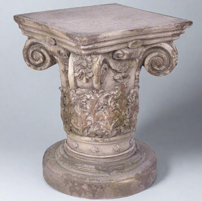 Decorative stone pedestal with intricate carvings on a light gray background