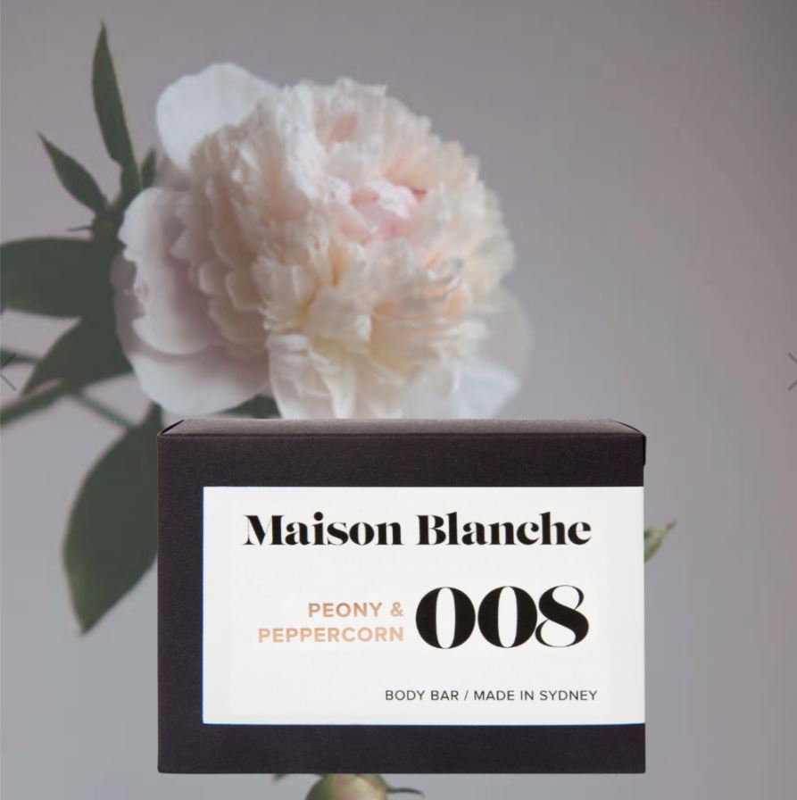 Maison Blanche body bar with a white flower in the background