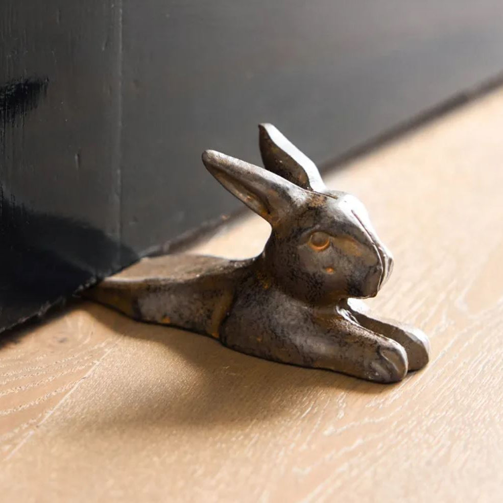 Decorative metal rabbit figurine on a wooden surface