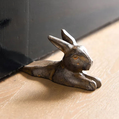 Decorative metal rabbit figurine on a wooden surface
