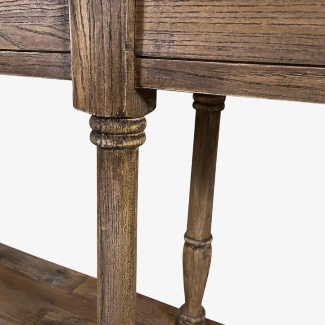 Close-up of a rustic wooden table leg with a distressed brown finish and turned detailing, shown against a plain white background.