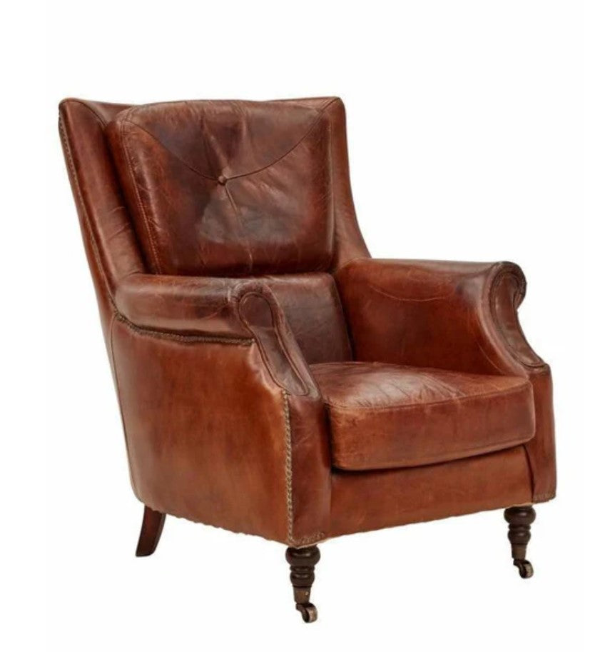 A brown leather armchair with a tufted backrest and carved wooden legs.