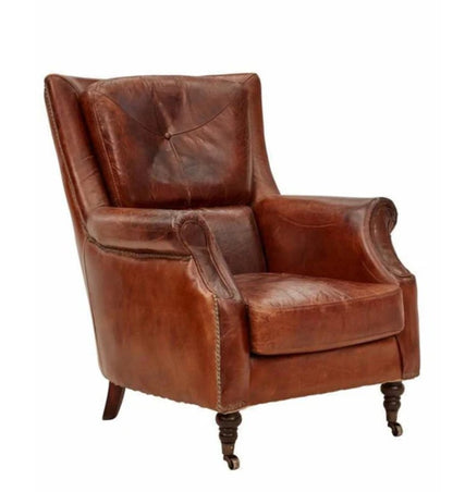 A brown leather armchair with a tufted backrest and carved wooden legs.