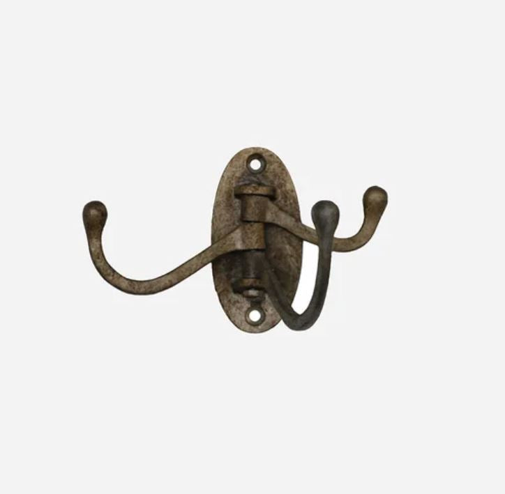 A rustic double coat rack hook with an oval backplate and two curved hooks, finished in an antique bronze or brown metal.