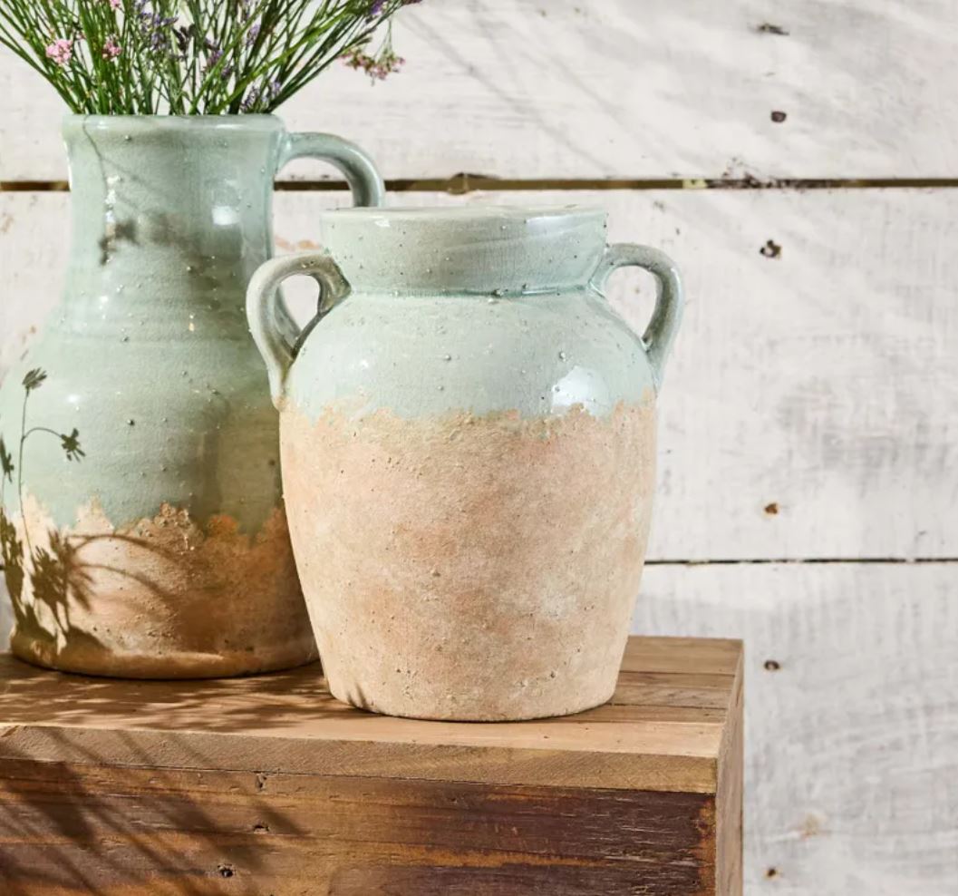 ceramic jars with floral decorations on a wooden surface.