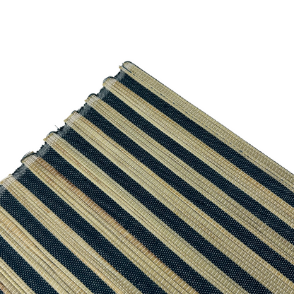 The Handwoven Diah Water Hyacinth Navy & Natural Striped Placemat - Set Of 4 are sure to elevate any table setting. Crafted from Water Hyacinth with a classic pattern, they can easily fit into many palettes, while providing protection to your tabletops. Corner close up.