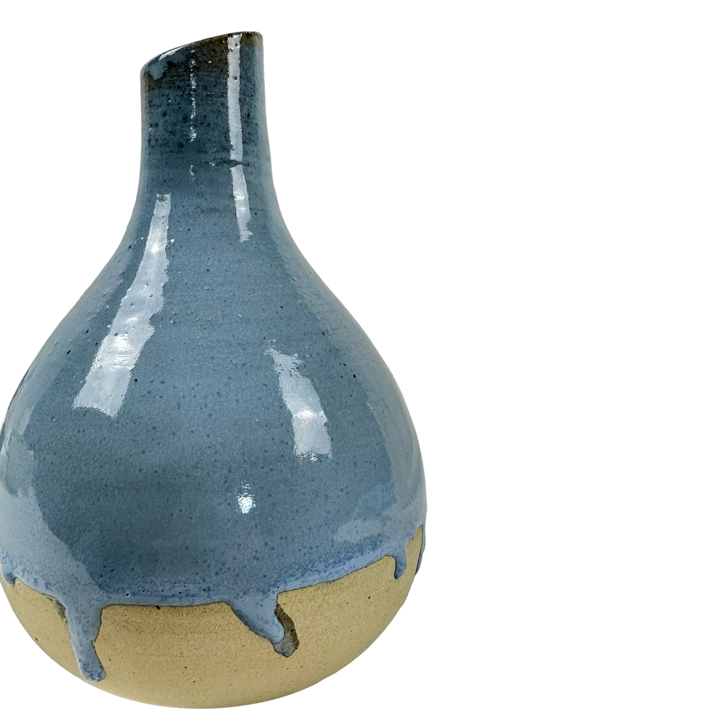 Indulge in the exquisite craftsmanship of Indonesian artisans with the Okta Handcarved Blue Ceramic Vase. Its stunning sky blue glaze beautifully complements the raw, unglazed base for a truly captivating piece. Detail.