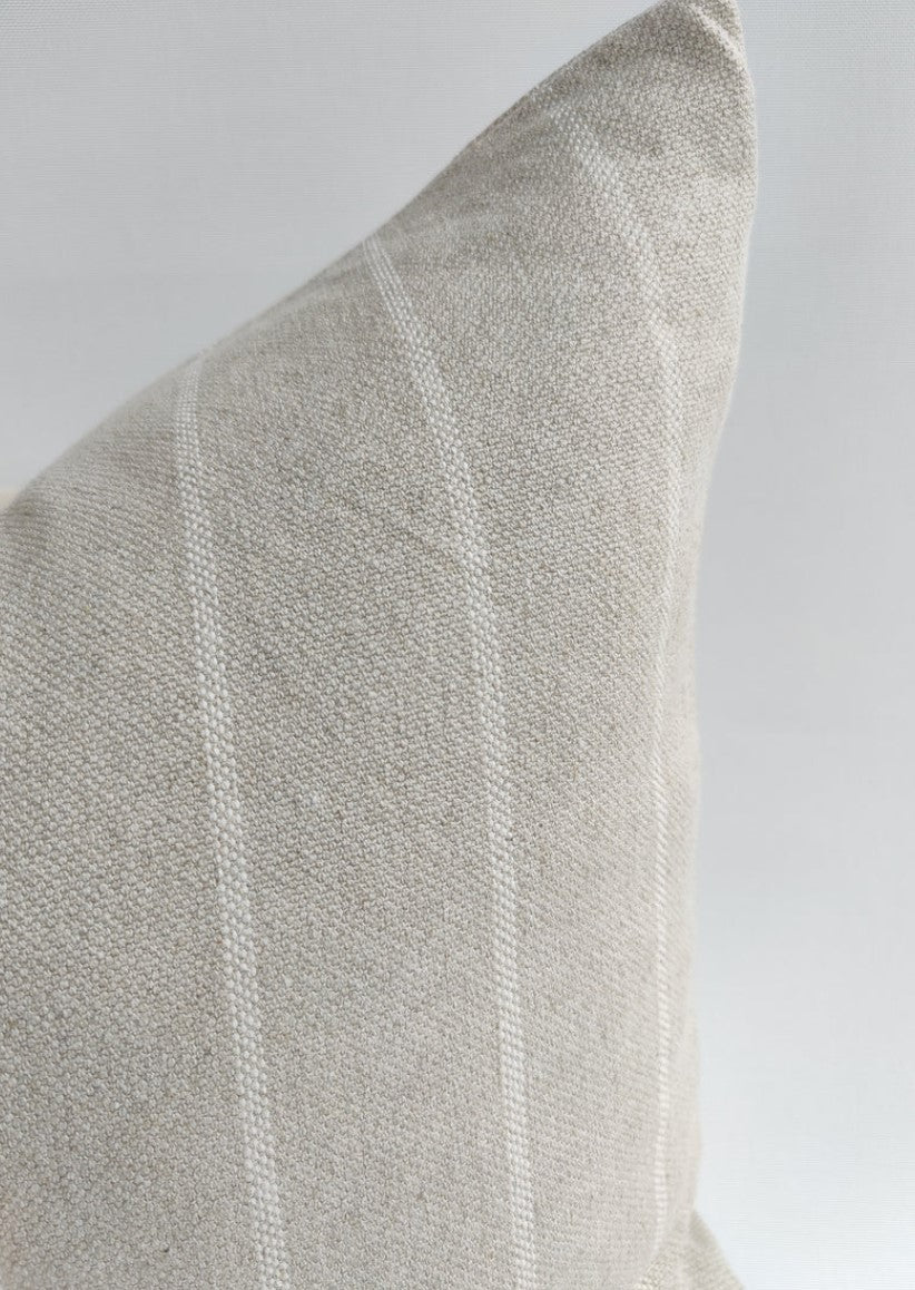 Experience the inviting warmth and rustic charm of your home with the Stéphane Striped Linen Cushion. This beautifully crafted cushion combines 60% linen and 40% cotton fabric, adorned with a simplified traditional pattern, and includes a discreet hidden zipper. Indulge in the perfect fusion of comfort and style. Close up detail.