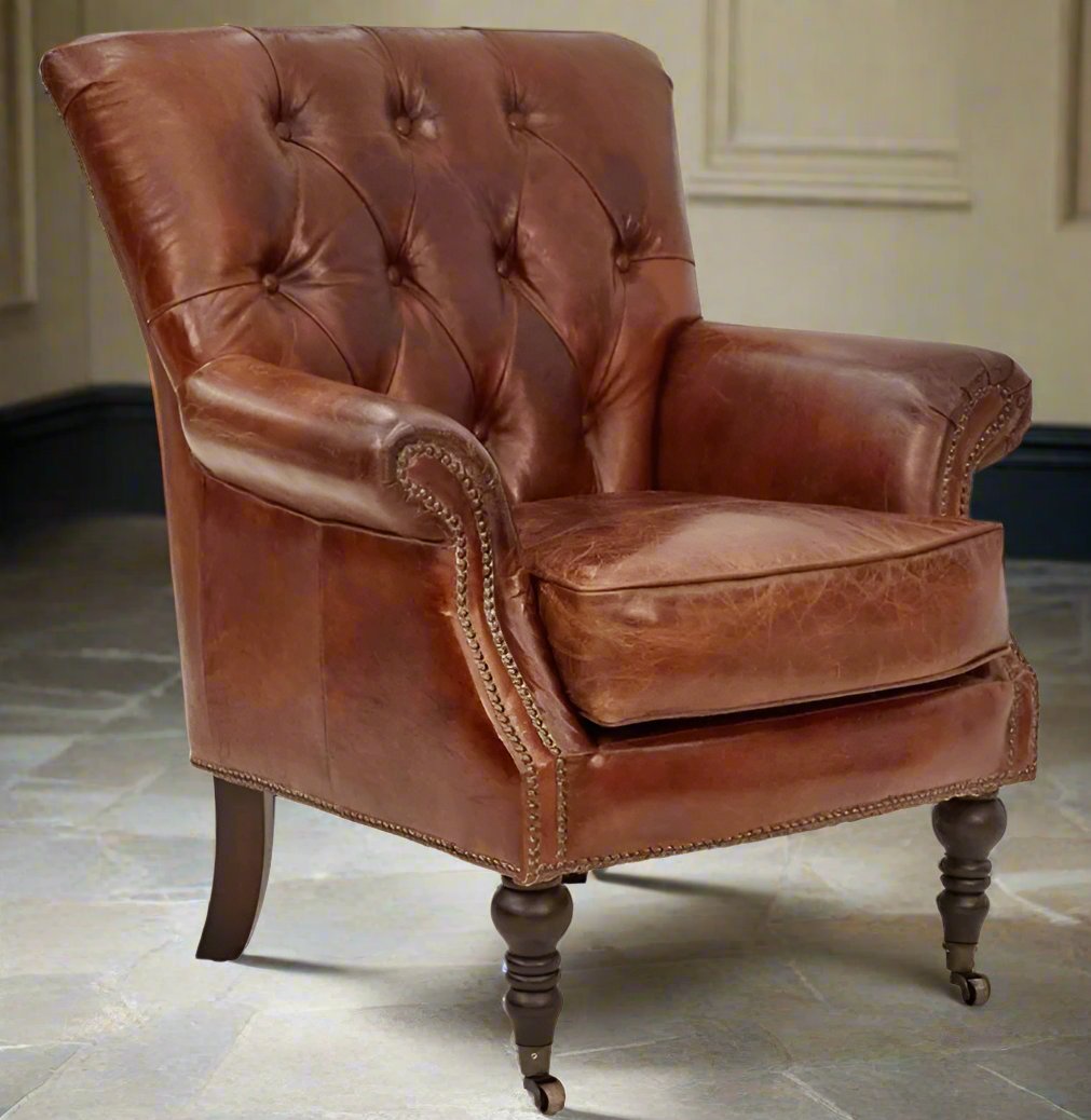 The Kensington armchair features aged top grain cow hide with classic diamond buttoning and brass stud detailing on the inside back. Its timber frame provides solid construction and durability, making it a lasting statement piece for any living space. Front