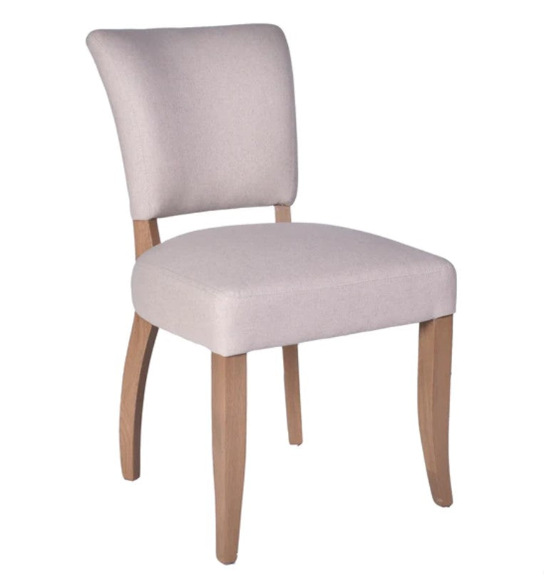 The Chelsea Dining Chair is constructed with a cream linen finish and features stud detailing on the back for a sophisticated, yet comfortable aesthetic. Front