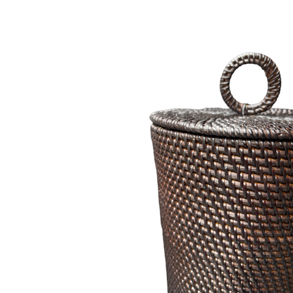 The Dasar Handwoven Rattan Basket's intricate weave adds a touch of organic and casual charm to your home decor. Its lid adds functionality, making it perfect for both styling and storage. Close up.