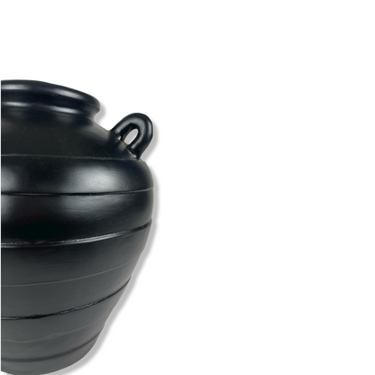 Experience the timeless elegance of the Barjac Pot, with its sleek black hue and classic lines that add depth and character to any home decor. Indulge in the unique style and sophistication this pot brings to your living space. Detail.